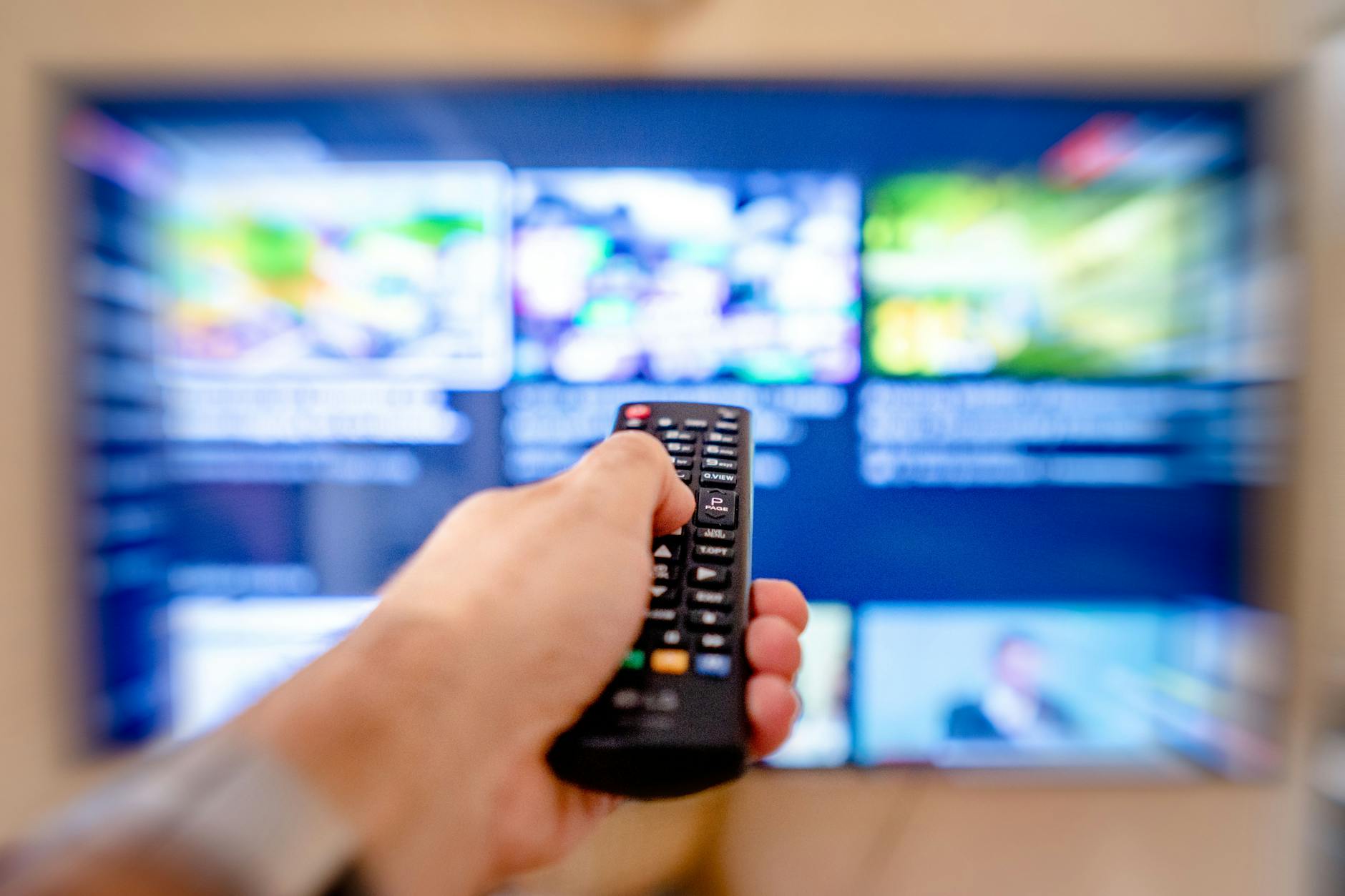 Modern television displaying streaming service interface with remote control