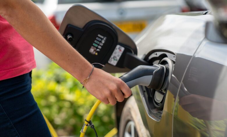 Electric vehicle charging station with charging cable connected to car
