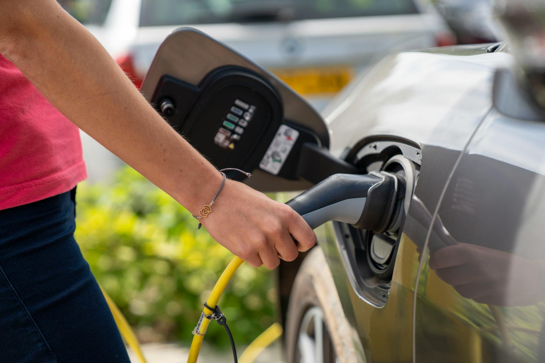 Electric vehicle charging station with charging cable connected to car