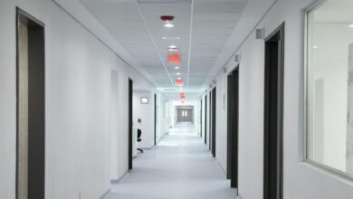 Empty hospital corridor with medical equipment and patient rooms