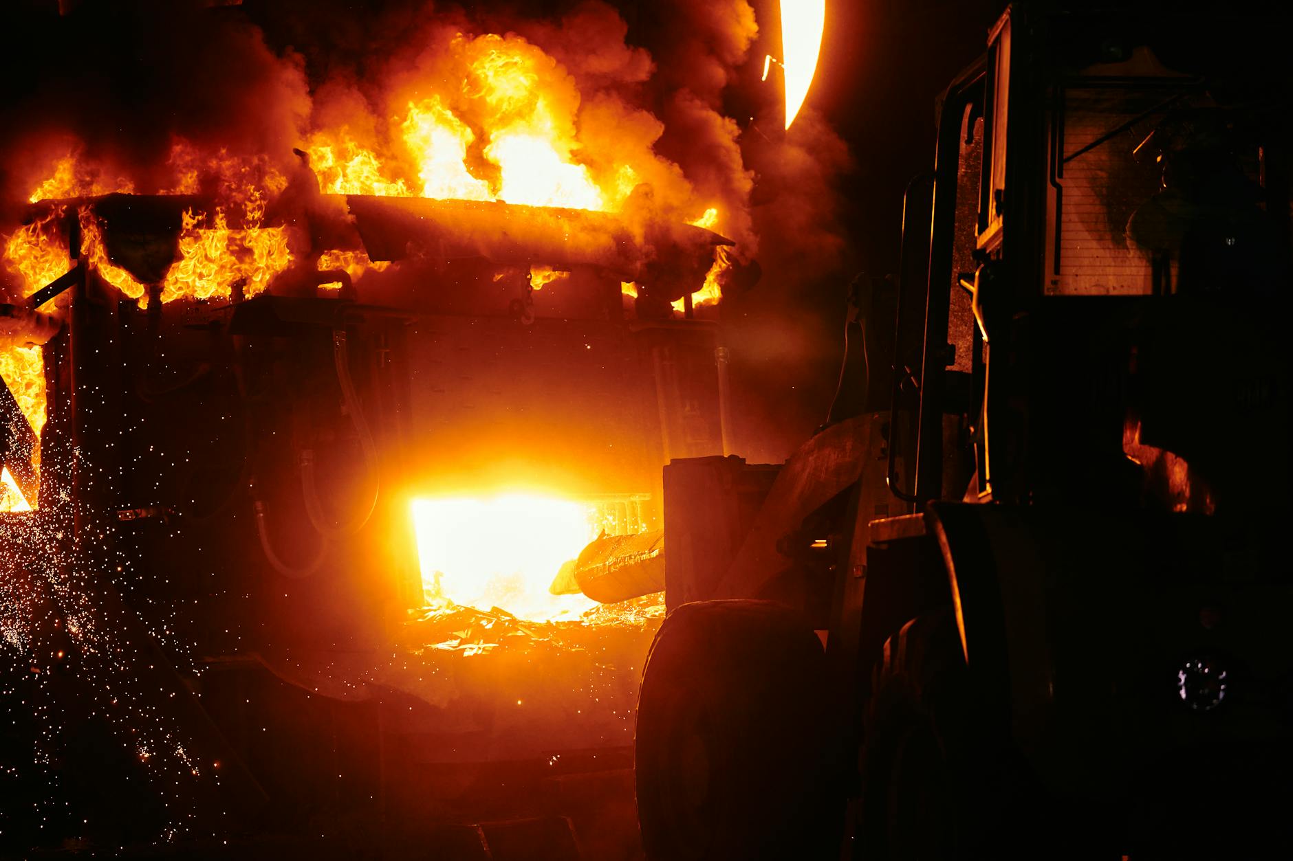 Large industrial fire with thick black smoke rising into the sky