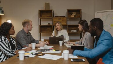 Business professionals collaborating in modern office environment with computers and communication tools