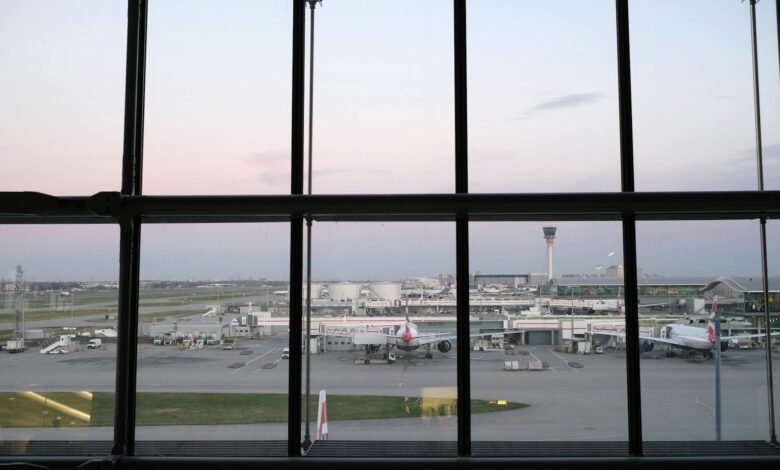 Busy airport terminal with passengers and flight information displays showing delays and cancellations