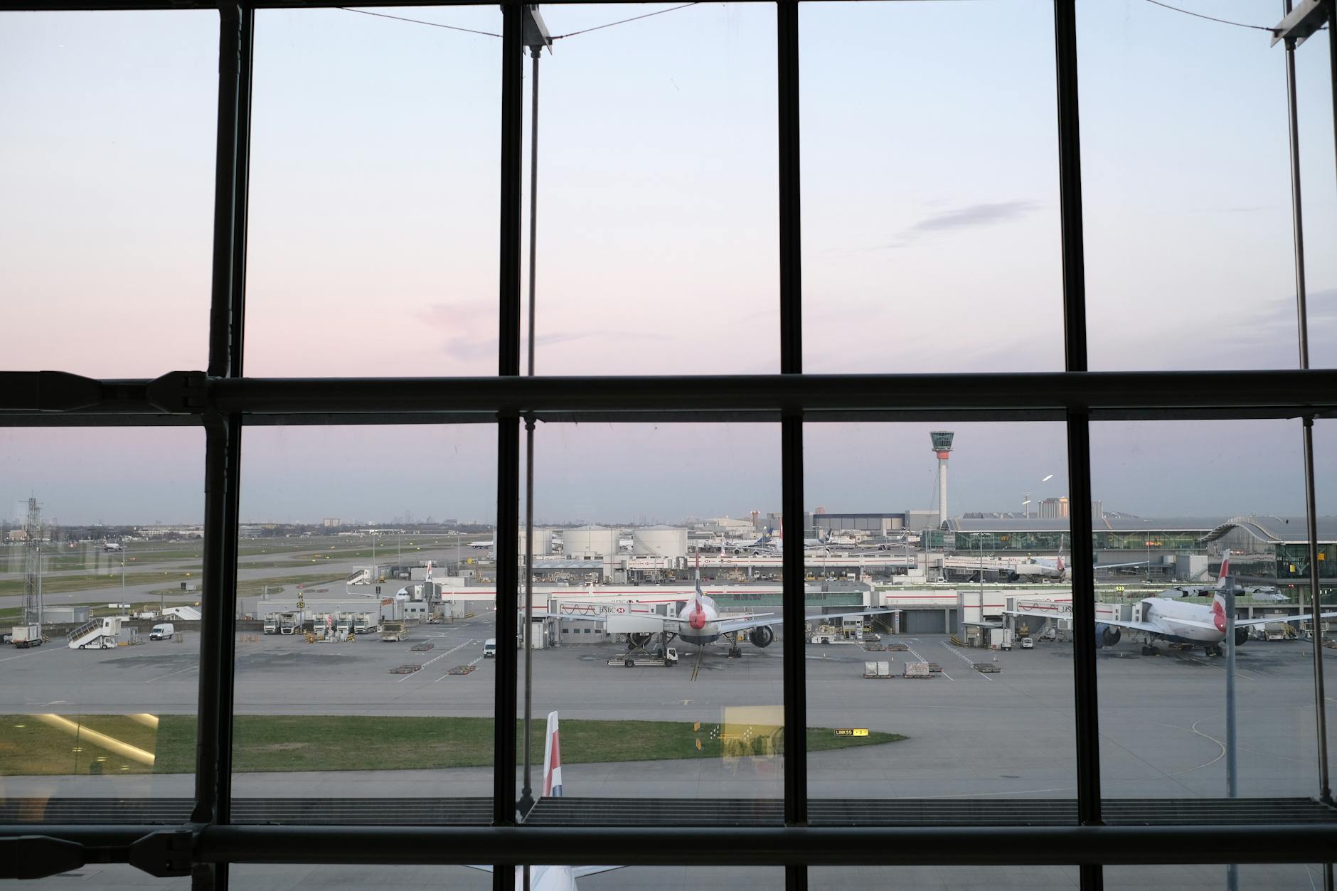 Busy airport terminal with passengers and flight information displays showing delays and cancellations