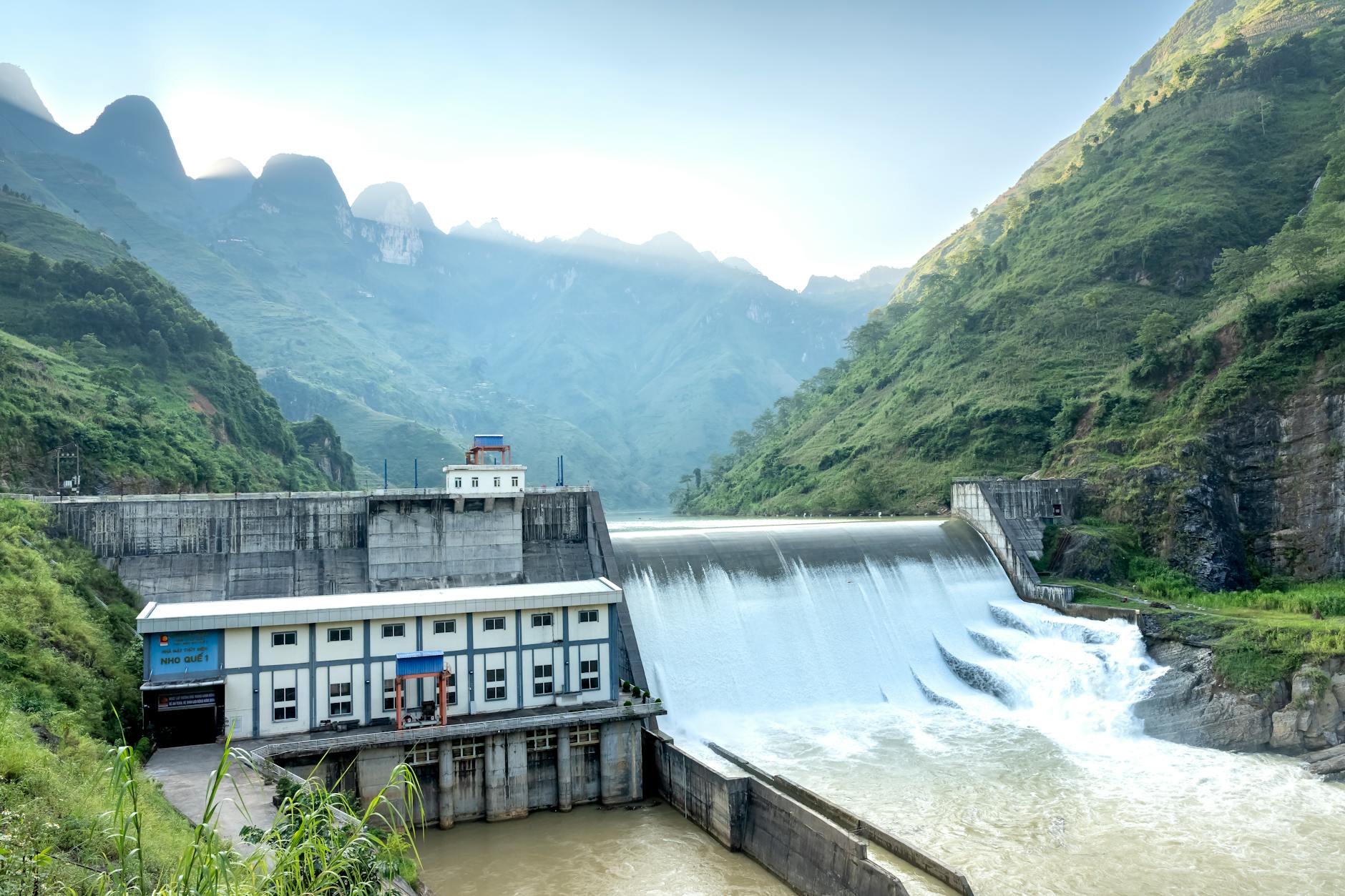 Large hydroelectric dam structure with water flowing through spillways