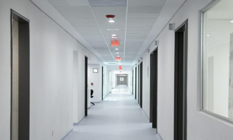 Empty hospital hallway with medical equipment and patient rooms