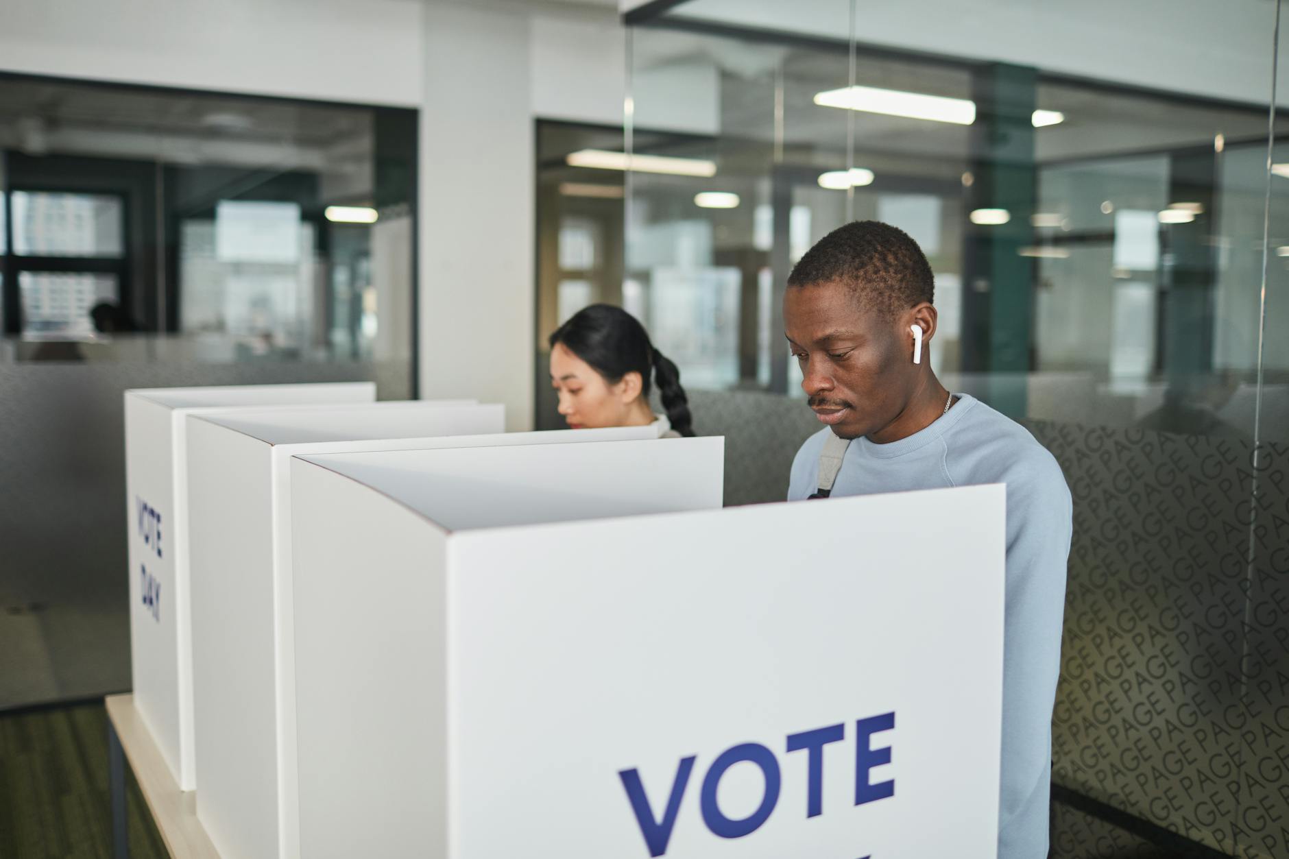 Person casting ballot at voting station during election