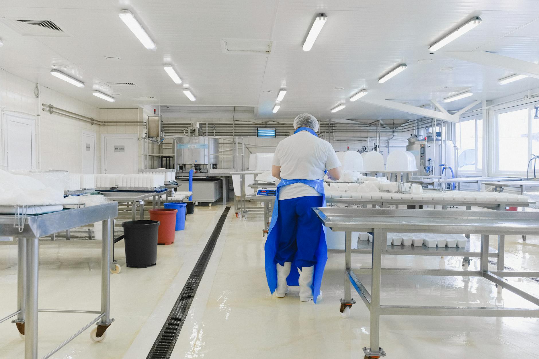 Workers in protective suits operating precision equipment in sterile manufacturing environment