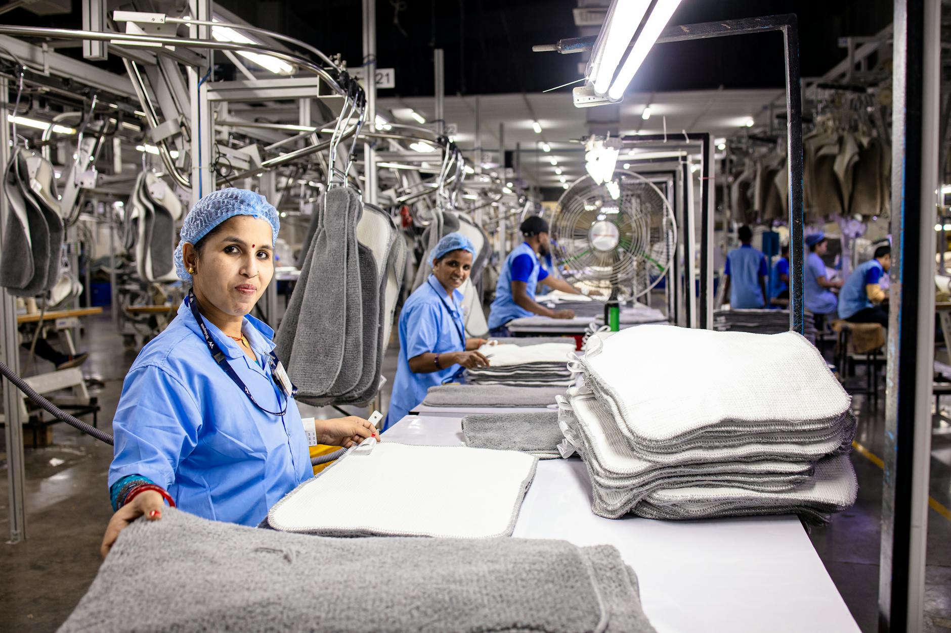 Factory workers on assembly line showing manufacturing labor needs driving immigration policy
