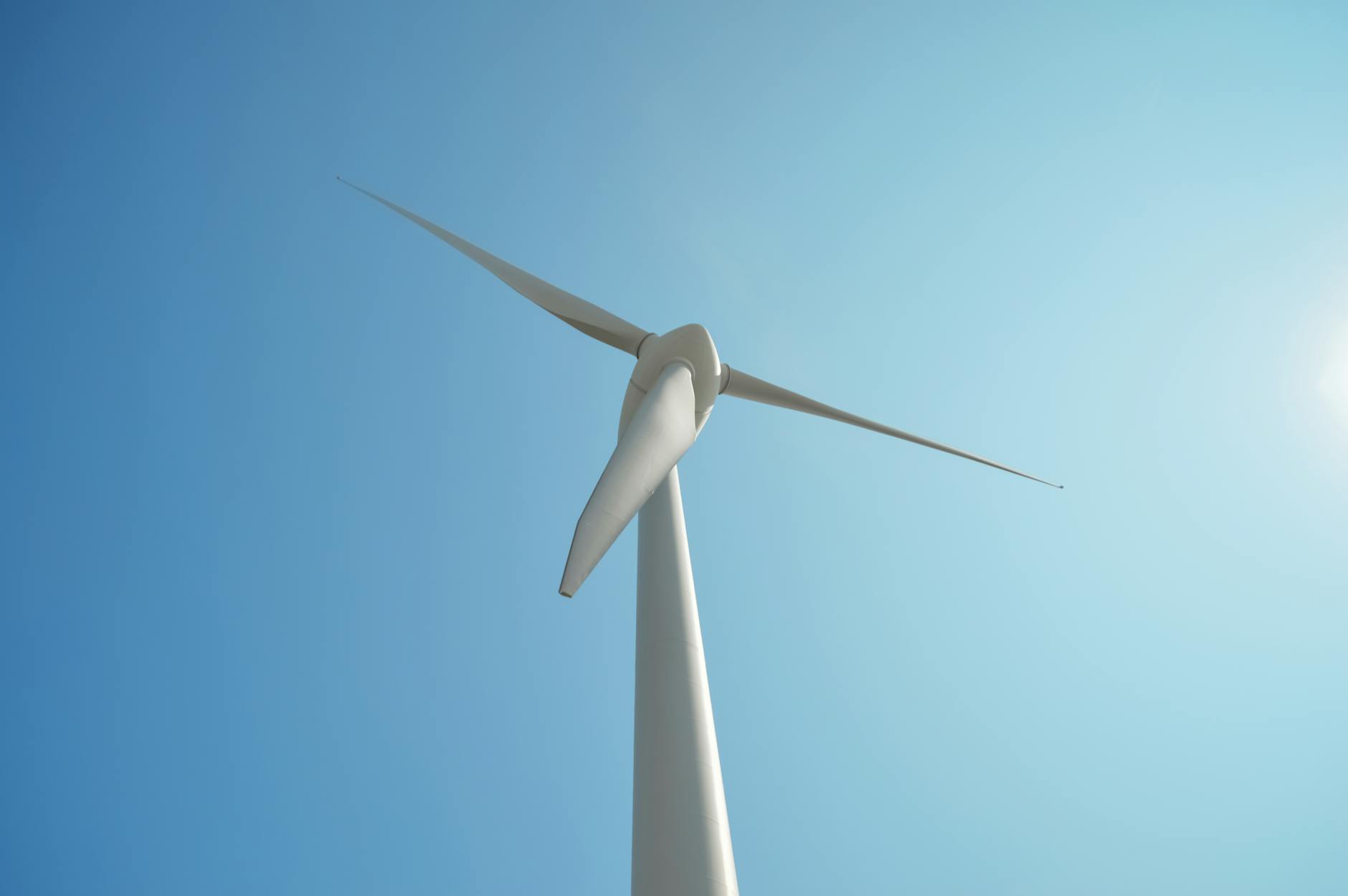 Row of wind turbines against blue sky generating renewable energy