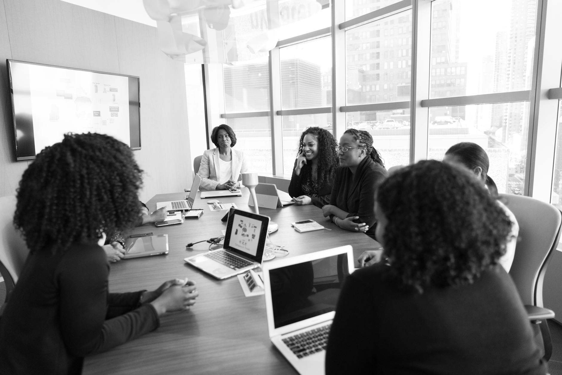 Business professionals reviewing cloud computing data on laptops and tablets in modern office