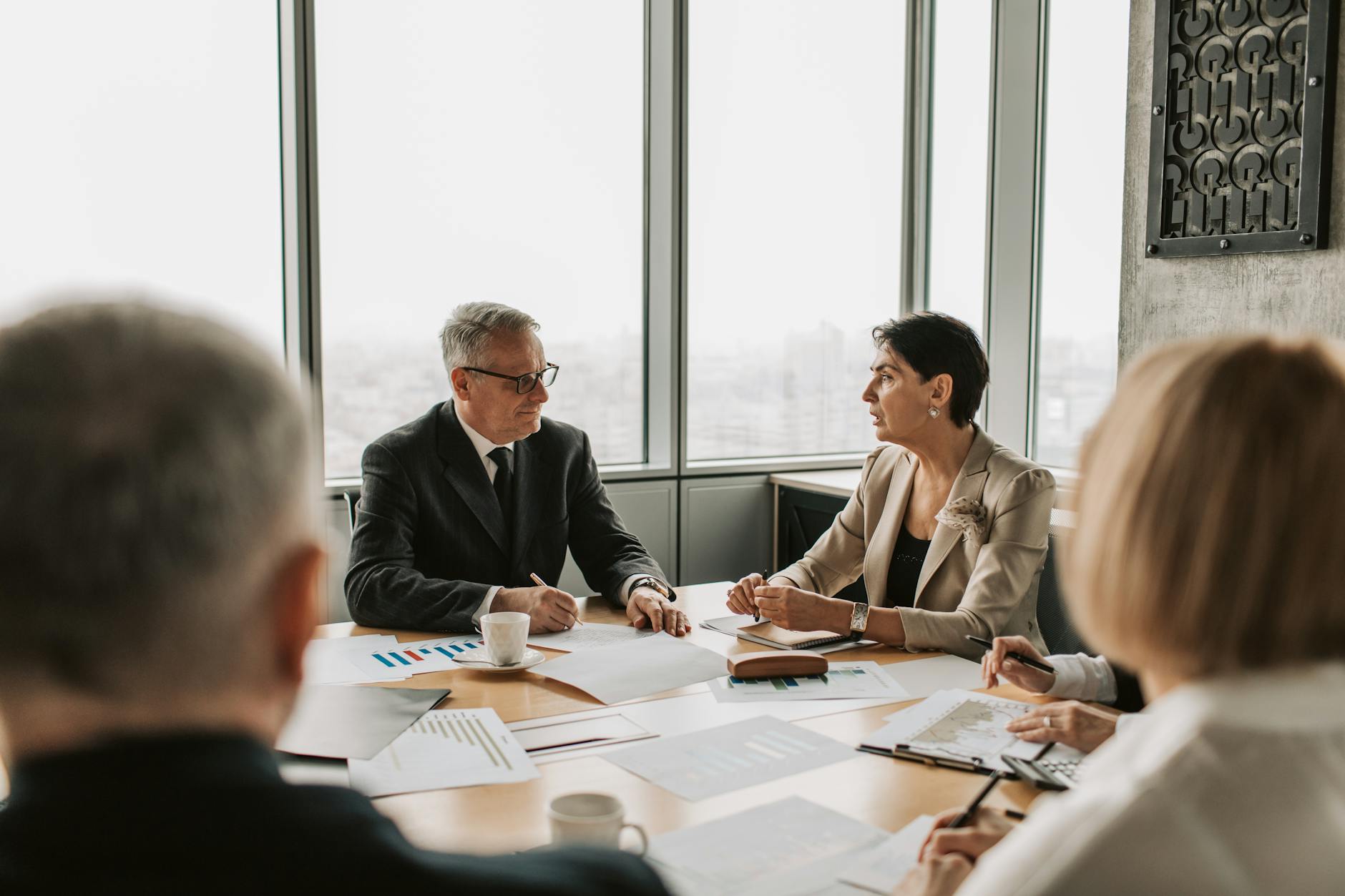 Corporate business meeting setting with professionals discussing regulatory and legal matters