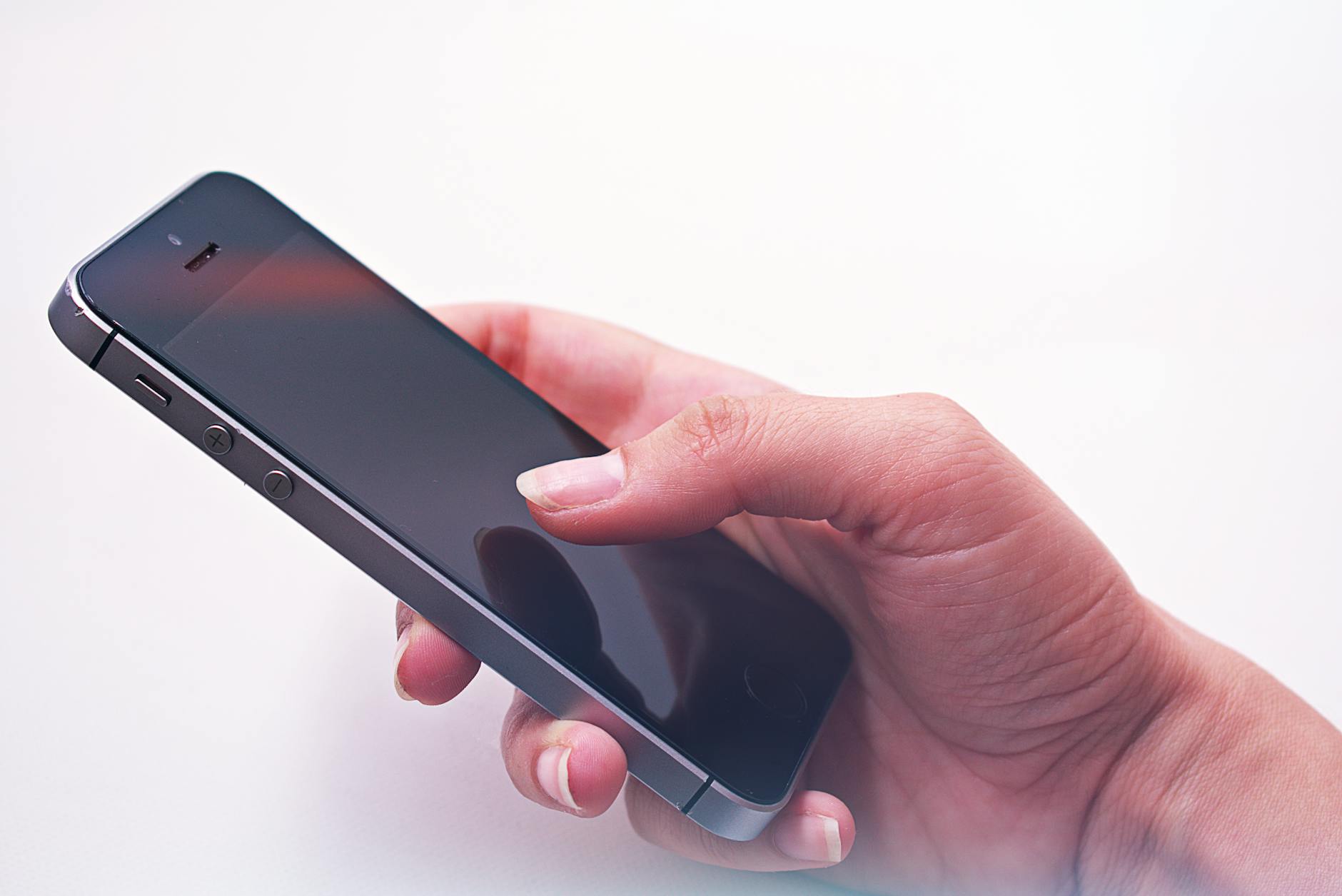 Hand holding smartphone displaying streaming video content on screen