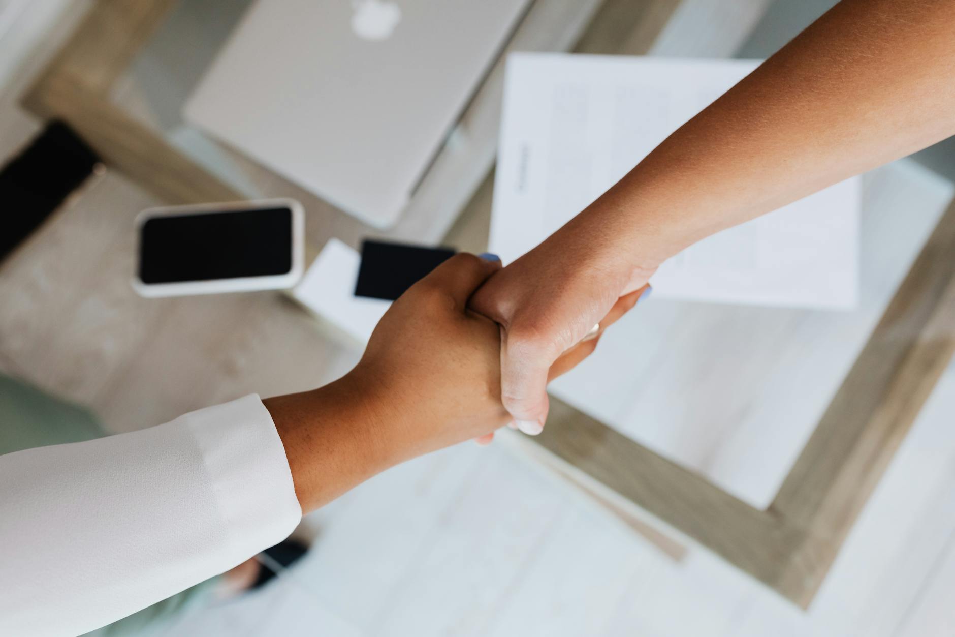 Professional handshake representing business partnership and competitive market dynamics