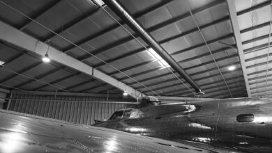 Workers on a commercial aircraft assembly line inside a large manufacturing facility