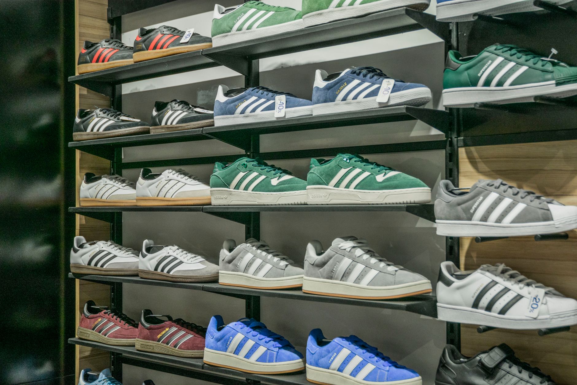 Rows of athletic sneakers displayed on shelves in a retail store