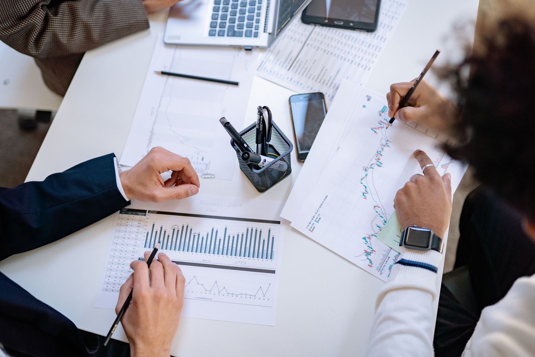 Corporate executives reviewing documents and charts during a strategy meeting