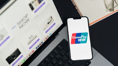 Person using smartphone for mobile payment at checkout counter