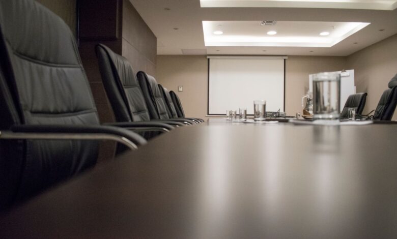 Empty corporate boardroom with chairs around a long conference table