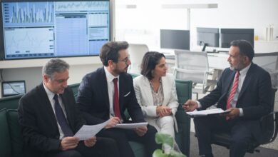 Corporate banking professionals in a formal office meeting discussing client strategy