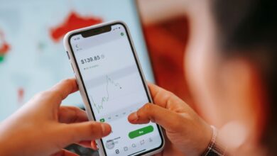 Person using a mobile trading app on a smartphone to buy stocks and cryptocurrency