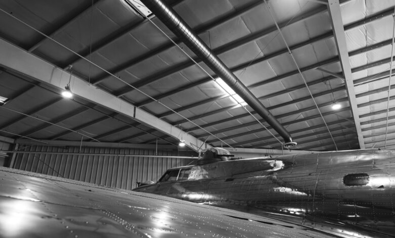 Commercial aircraft on a manufacturing assembly line inside a large factory facility
