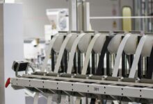 Workers on a modern electronics assembly line representing iPhone manufacturing operations