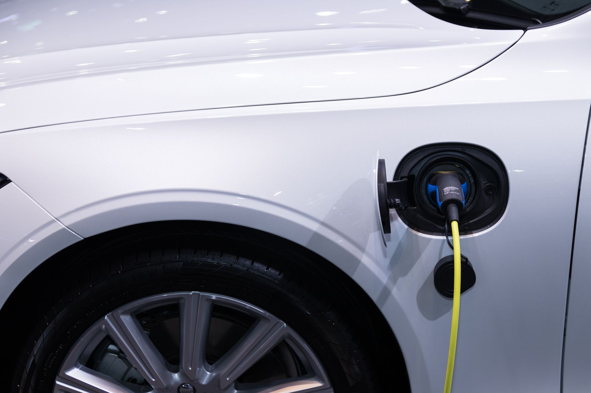 Electric vehicle plugged into a charging station in an urban setting