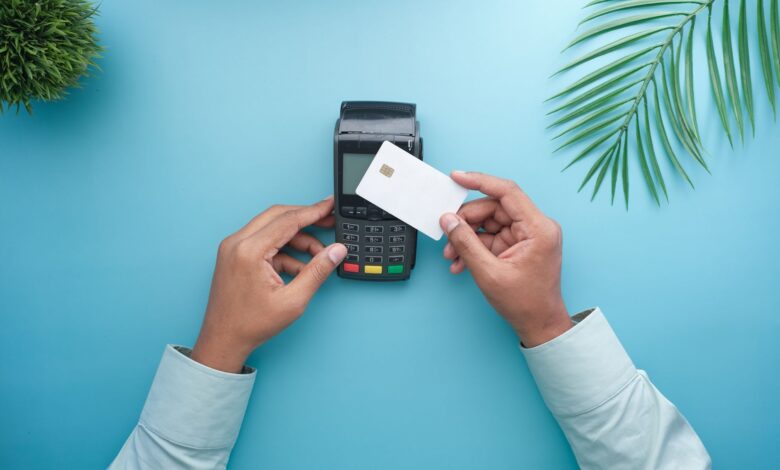 A shopper using a contactless payment terminal at a retail checkout counter