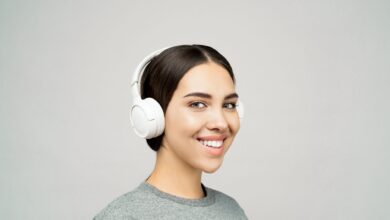Woman wearing headphones listening to audio content on a smartphone