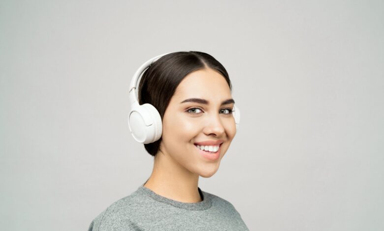Woman wearing headphones listening to audio content on a smartphone