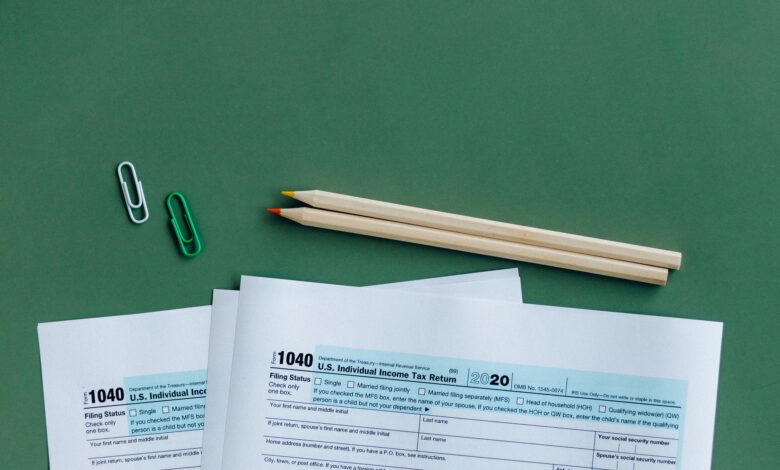 Person sitting at a desk organizing tax documents and forms during tax season