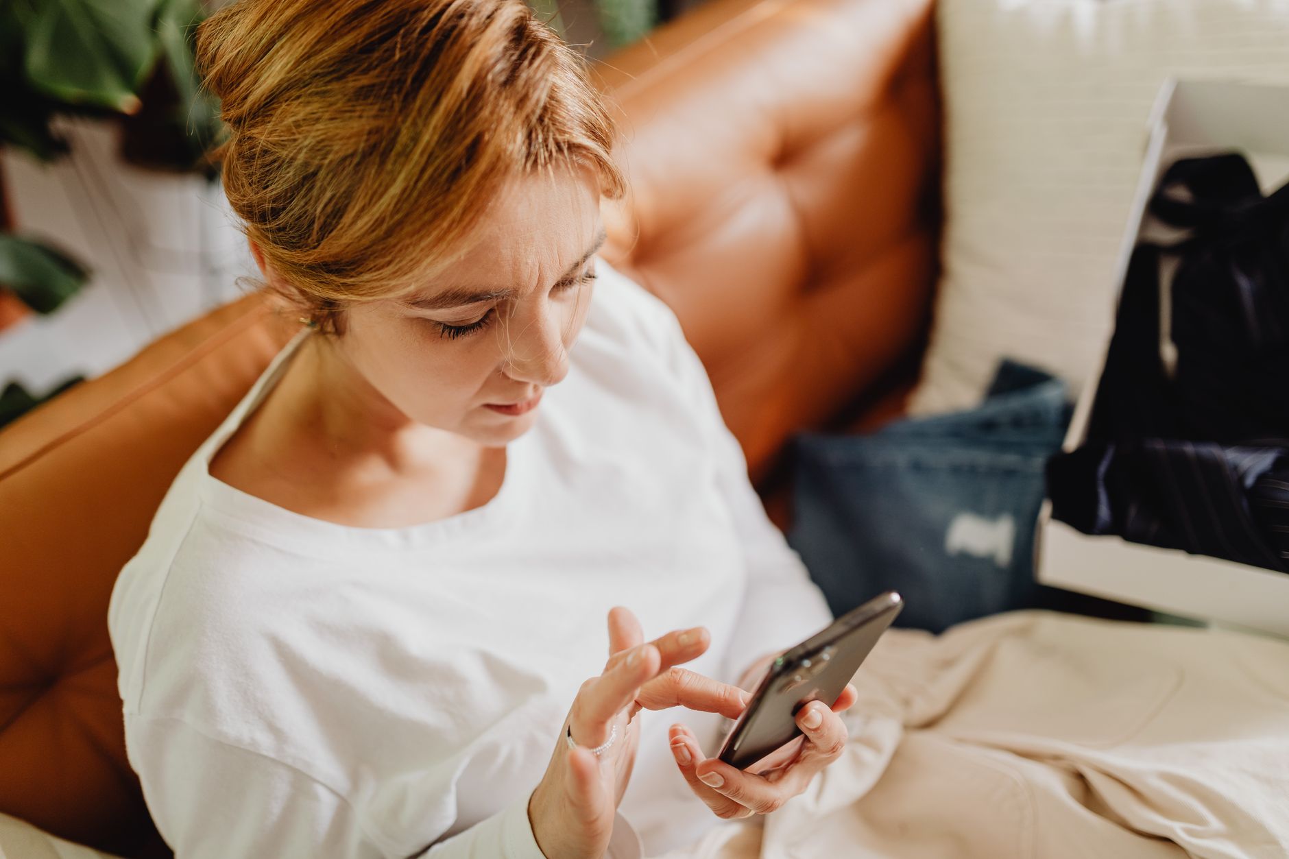 Person browsing a shopping app on a smartphone with product listings visible on screen