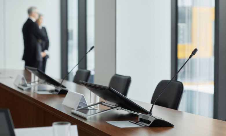 Empty corporate boardroom with large conference table representing governance restructuring discussions