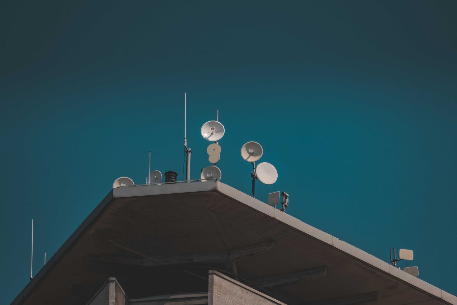Large satellite dish pointed toward a clear blue sky representing broadband connectivity infrastructure